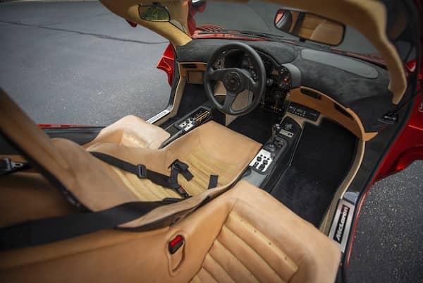 The Interior of McLaren F1 LM with 3-seat configuration. The driver seat is in the middle and both doors of the car wide open up top.