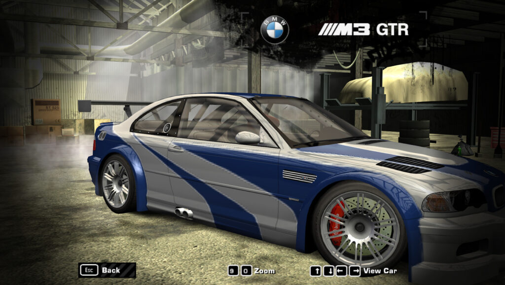 A screenshot of the car selection menu from the 2005 very famous game Need for Speed Most Wanted There's a BMW M3 GTR with Wide Body Kits, Racing Roll Cage, Racing Longtail Spoiler and Blue Vinyl's on a Silver coating paint. The background is one of the hideout streets of a game.