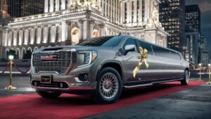 A majestic GMC limousine, the epitome of luxury and elegance, is parked on a red carpet in front of a grand, illuminated building. The limousine is adorned with a shining gold ribbon and a personalized license plate. The vehicle's sleek design is accentuated by its long, stretched body and large, gleaming wheels. The background features a bustling cityscape with skyscrapers reflecting the lights of the city. The overall atmosphere is one of glamour, sophistication, and high-class.