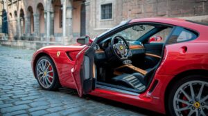 A photo of a red Ferrari 599 GTO parked on a cobblestone street. The car is in excellent condition, with shiny red paint and clean, black leather seats. The interior has a wooden dashboard with multiple dials and buttons. The background reveals ancient buildings with arches and windows. The lighting is soft.